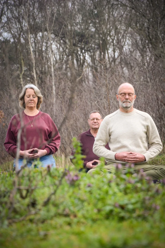 Robert Kizen en twee leden van het team van Zen Brabantse Wal mediteren buiten in de natuur.