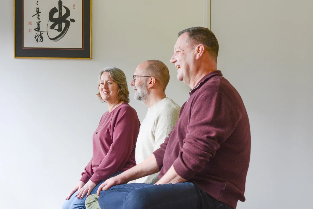 Robert Kizen en twee leden van het team van Zen Brabantse Wal nemen een moment om ontspannen over zenmeditatie te praten.